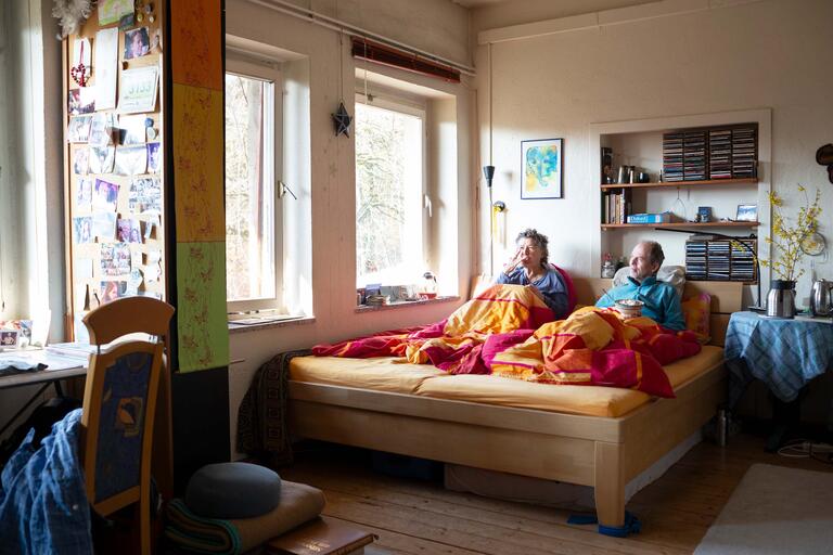 Bettina und Georg sind verheiratet und leben hier in getrennten Wohngemeinschaften. Zu ihrem Morgenritual gehört das gemeinsame Frühstück im Bett.