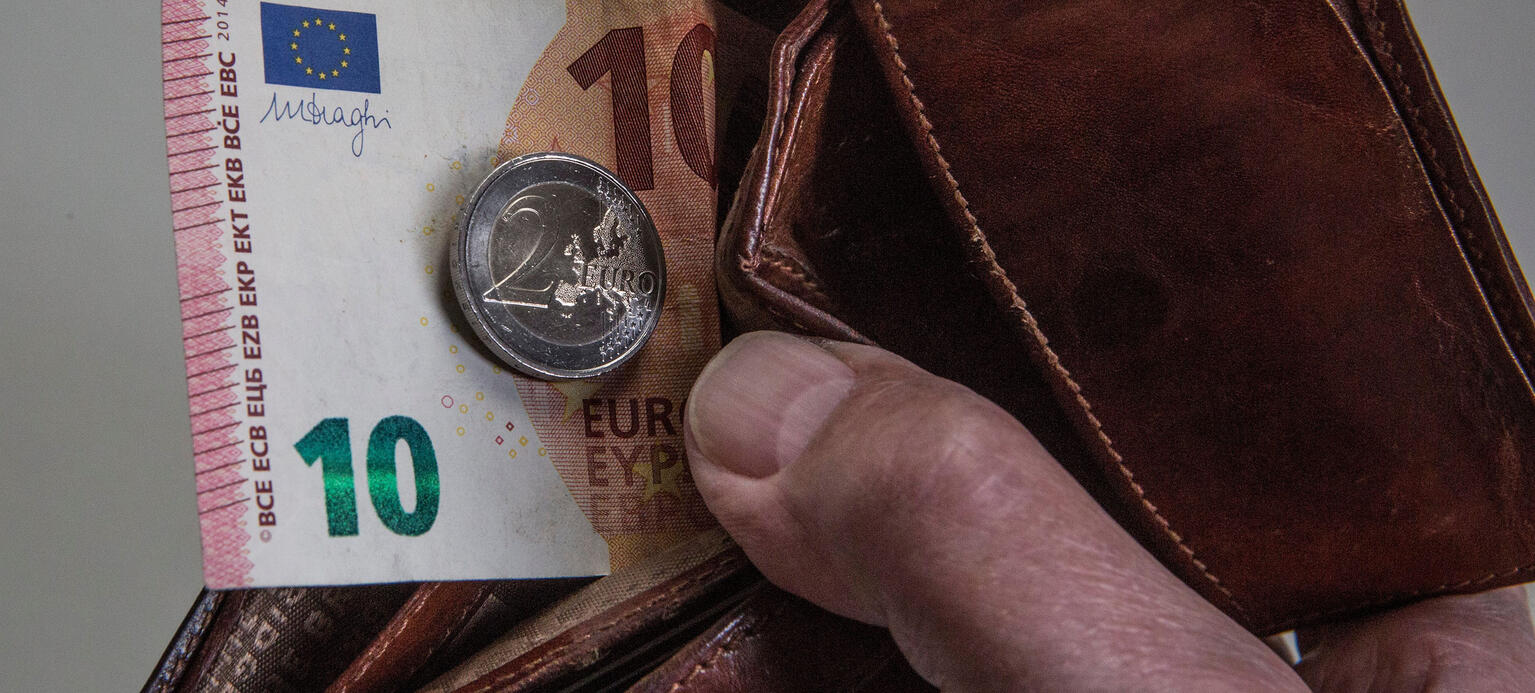 Symbol photo on the subject of minimum wage, subsistence level, livelihood, etc. The picture shows a 10 Euro banknote and a 2 Euro coin in a purse. 