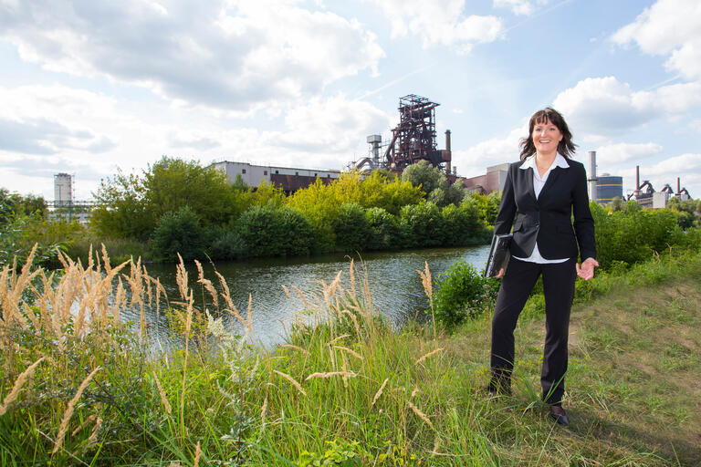 PR-Vertreterin Kathleen Kollewe vor dem Stahlwerk von ArcelorMittal in Eisenhüttenstadt: „Man muss zwischen Wirtschaft und Politik übersetzen.“