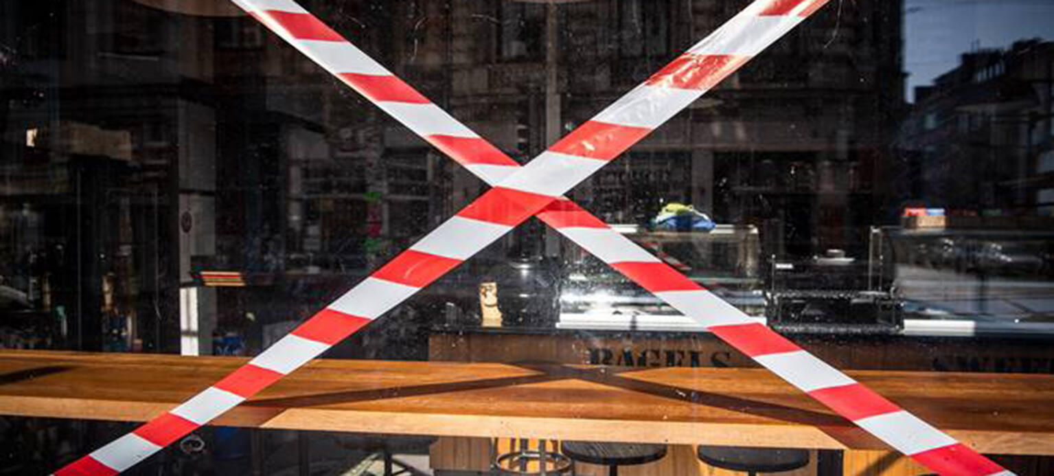 In einem Fenster eines geschloseenen Cafes im Bremer 'Viertel' hängt ein Absperrband.