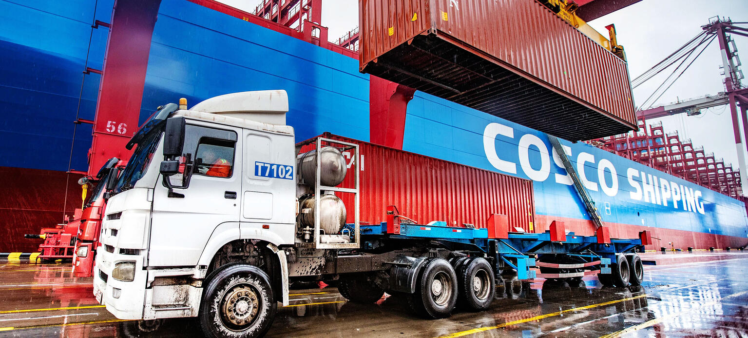 A container is loaded onto a truck on a quay in a container terminal at the Port of Qingdao