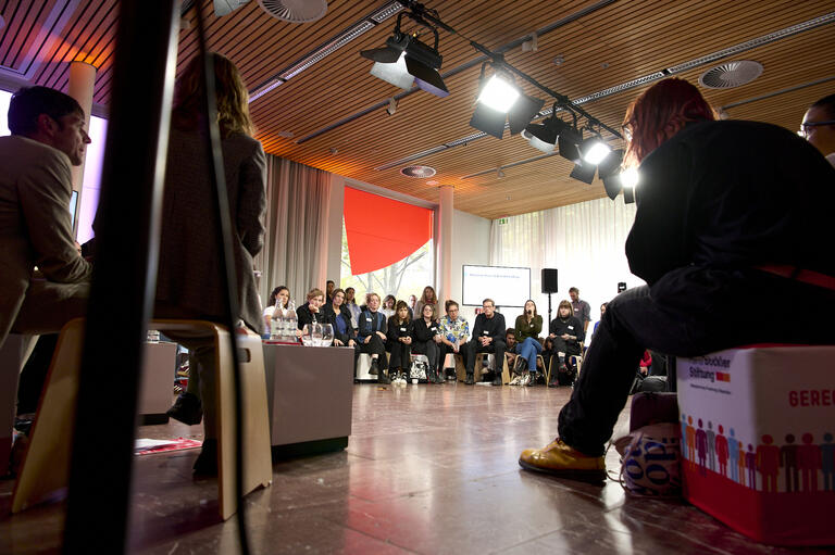 Menschen sitzen in einer Runde und diskutieren