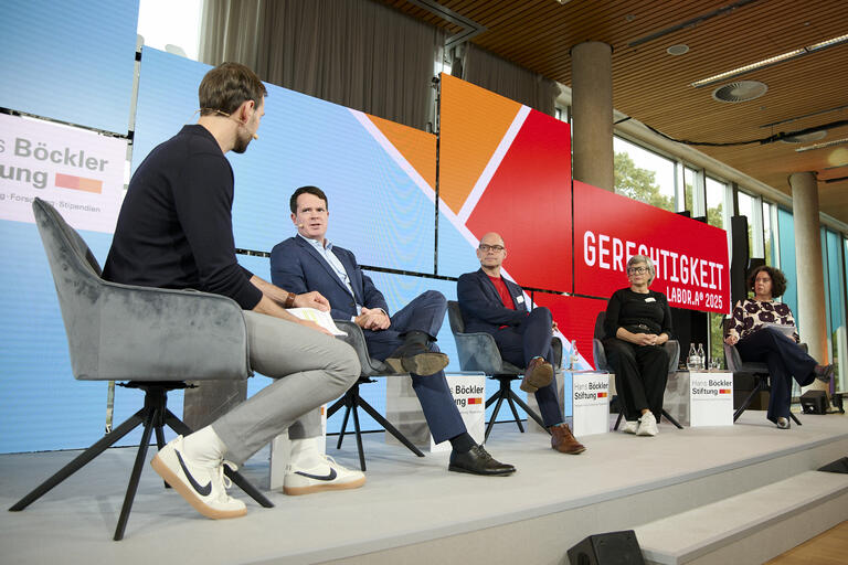 Diskutierende auf Podium