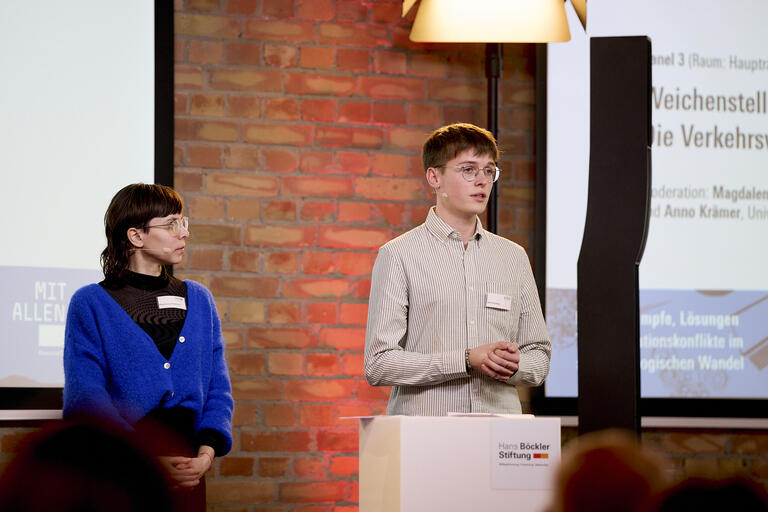 Eine Frau und ein Mann stehen auf dem Podium