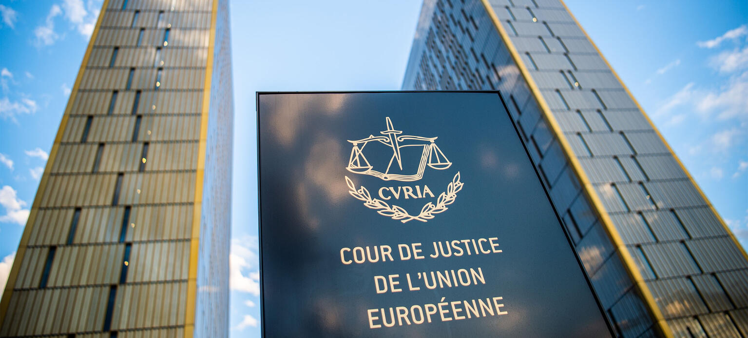 Das Bild zeigt ein Schild vor den Bürotürmen des Europäischen Gerichtshofs mit der Aufschrift 'Cour de Justice de l'union Européene' im Europaviertel auf dem Kirchberg. 