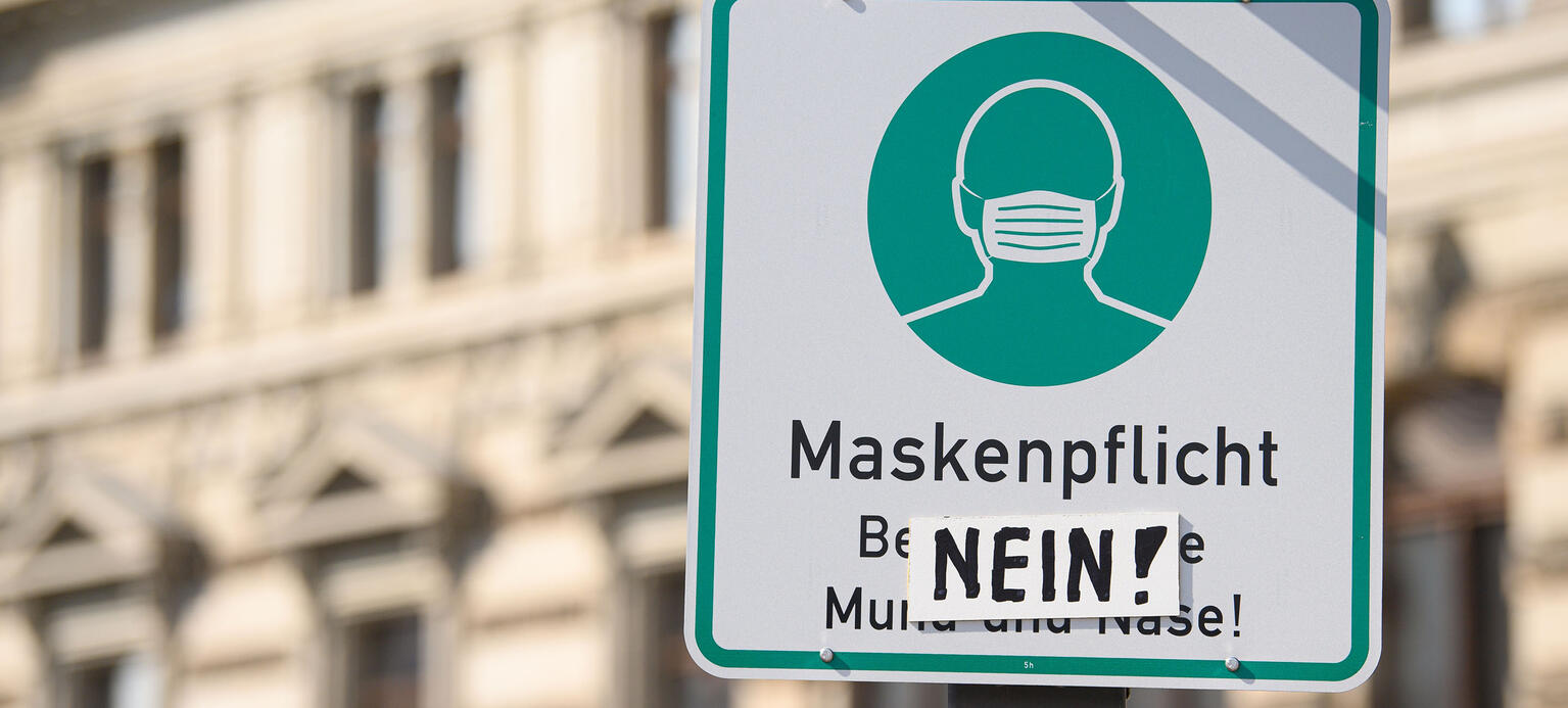 Ein Hinweisschild für die Maskenpflicht im Rahmen der Bekämpfung der Corona-Pandemie ist in der Dresdner Innenstadt mit einem Stück Pappe mit der Aufschrift 'Nein!' überklebt
