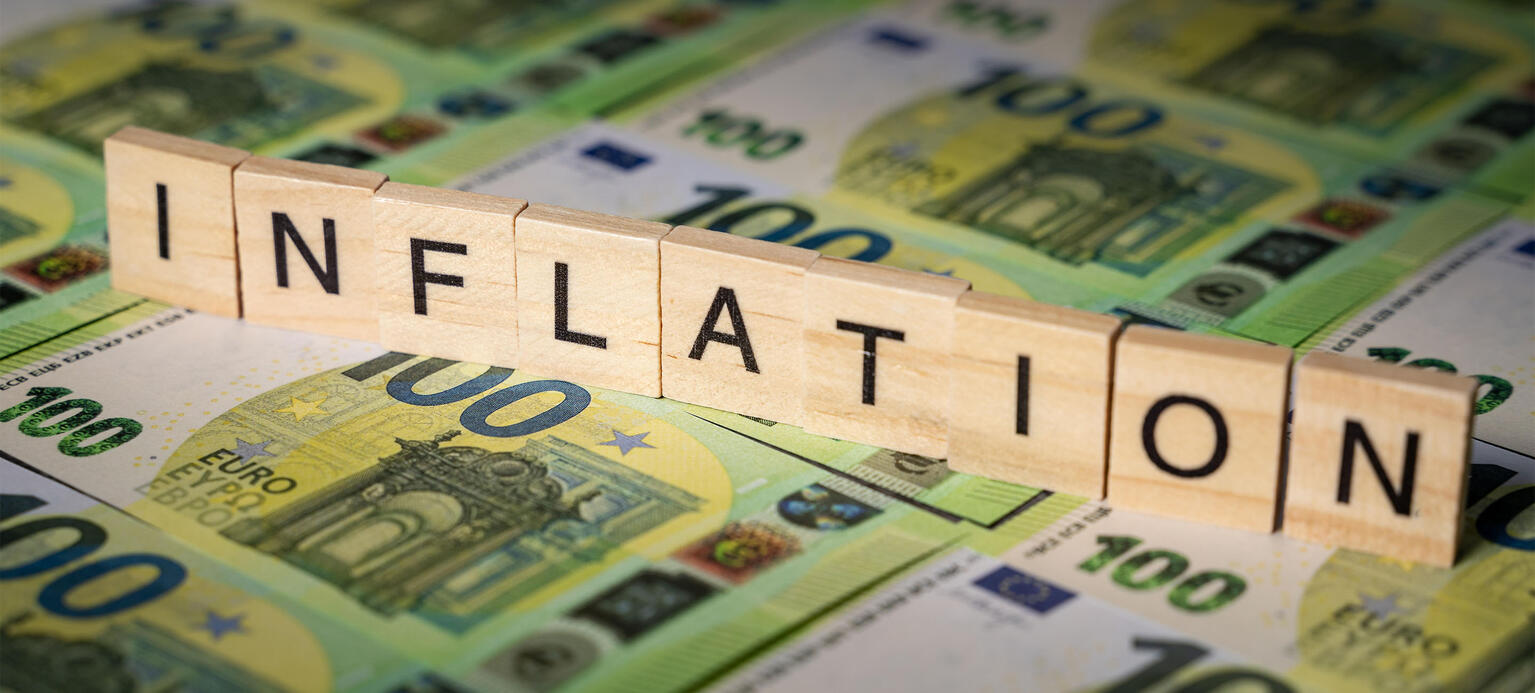 Holzwürfel mit der Aufschrift Inflation auf mehreren 100 Euro Geldscheinen, Geld wird wertlos, Inflation 