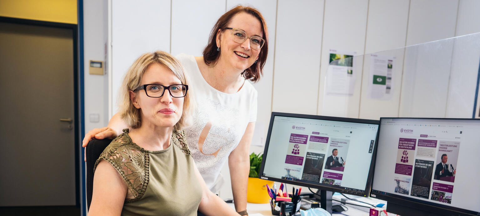 Die Schwerbehindertenvertreterin Tamara Eils (stehend) und Mitarbeiterin Miriam Stihulka in einem Büro mit einem Spezialstuhl bei Evonik in Hanau.