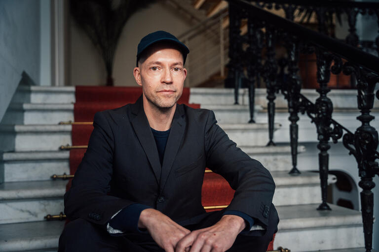 Roman Klink, Drehbuchautor und -lektor auf einer Treppe