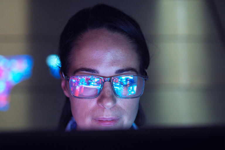 Engineer examining AI technology with reflection on eyeglasses - Künstliche Intelligenz
