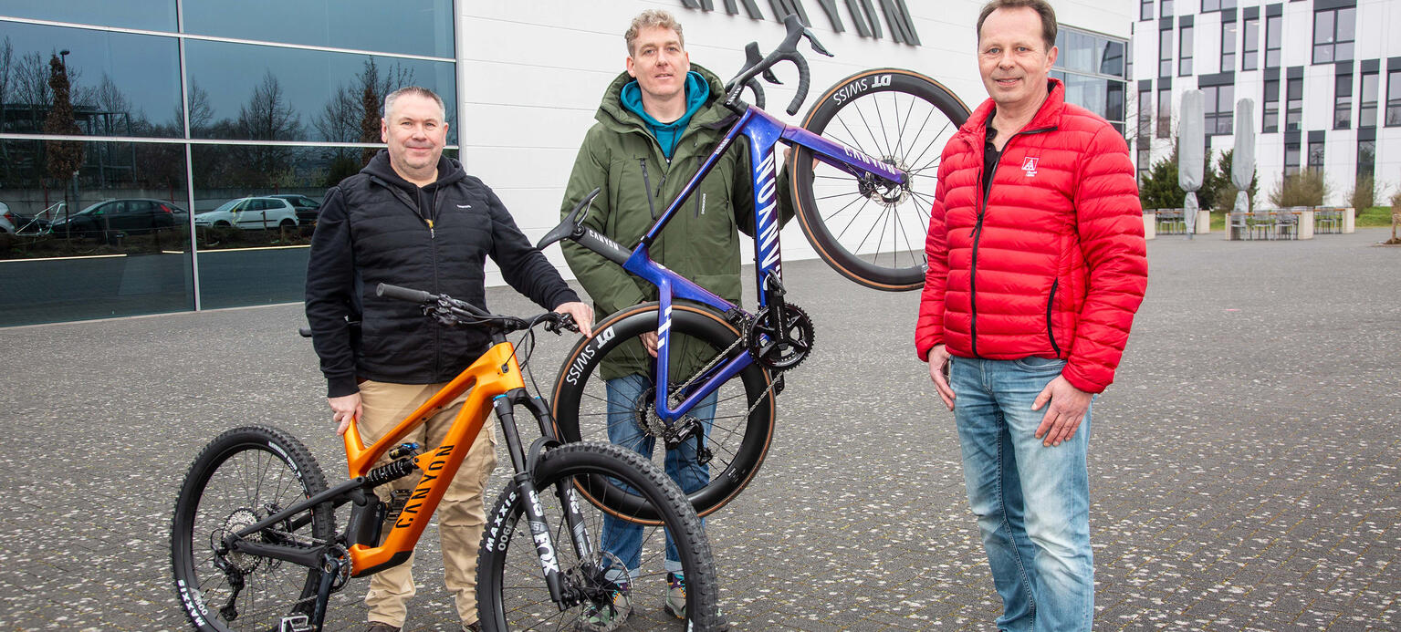 Team beim Fahrradhersteller Canyon mit Rädern: Waldemar van Heesch (links), Mitarbeiter in der Verpackung, mit Betriebsrat Robert Brückner (Mitte) und IG Metall-Sekretär Markus Friedel