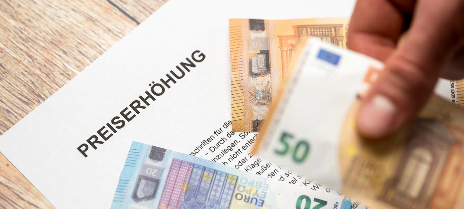 Mitteilung der Preiserhöhung auf einem Brief zusammen mit Euro Geldscheinen - Inflation