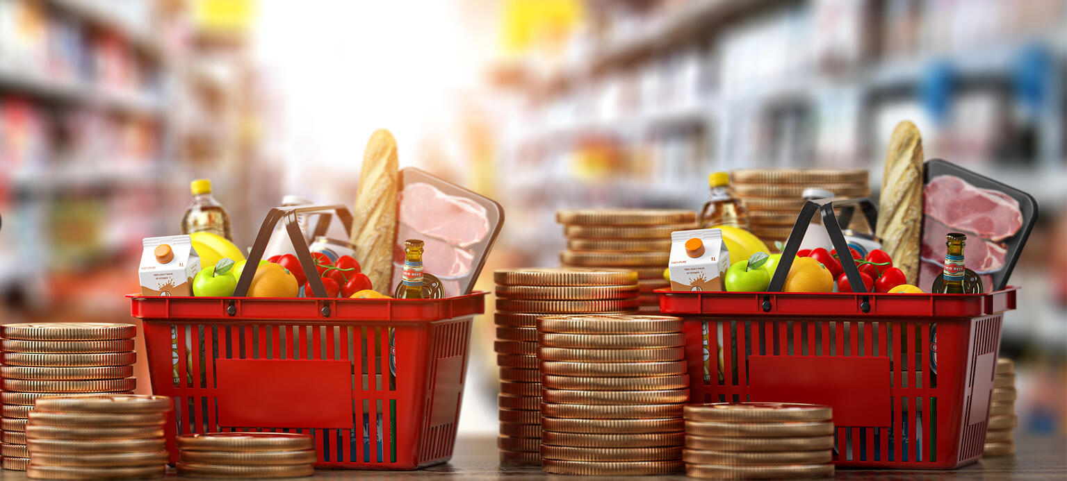 Growth of food sales or growth of market basket or consumer price index concept. Shopping basket with foods with coin stacks in grocery shop. Inflationsmonitor