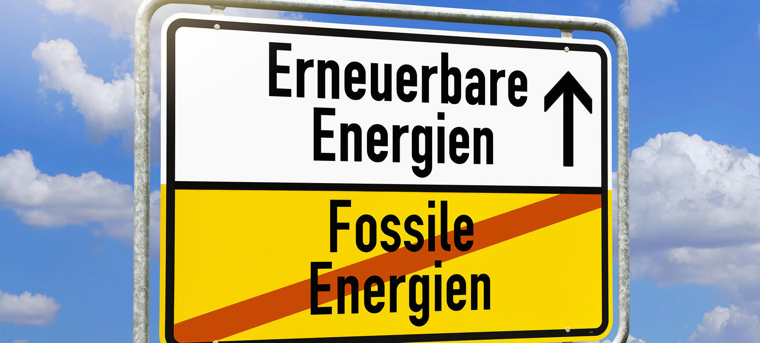 Schild mit Aufschrift Erneuerbare Energien und durchgestrichener Aufschrift Fossile Energien 