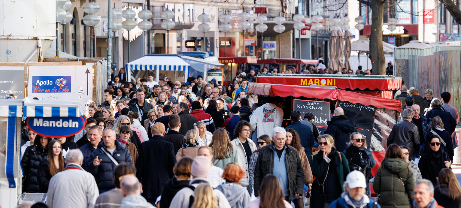 Zahlreiche Menschen gehen in der Innenstadt von München an Geschäften an der Kaufingerstraße vorüber.