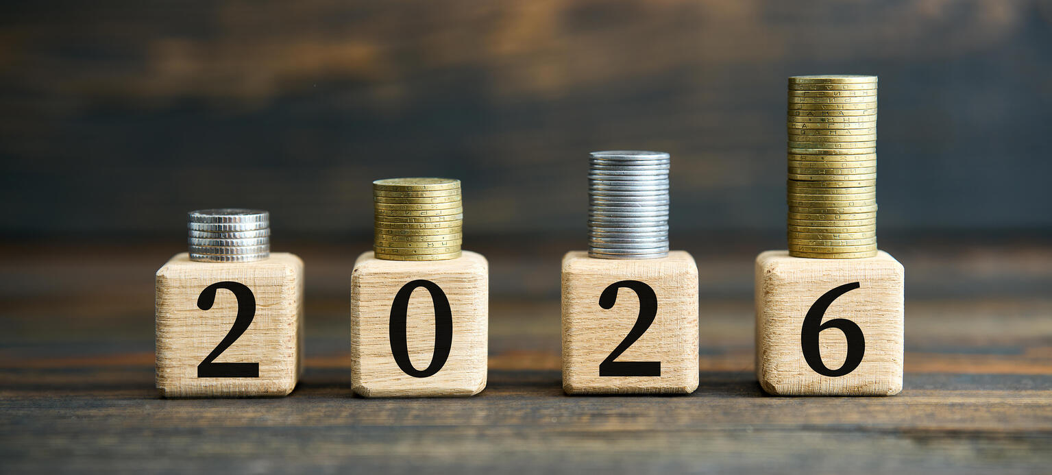 Würfel mit den einzelnen Zahlen 2, 0, 2, 6. Auf den Würfeln sind Münzen gestapelt.