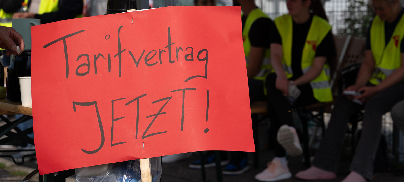 Auf einem roten Plakat vor der Fabrik von Birtat steht: «Tarifvertrag JETZT!».