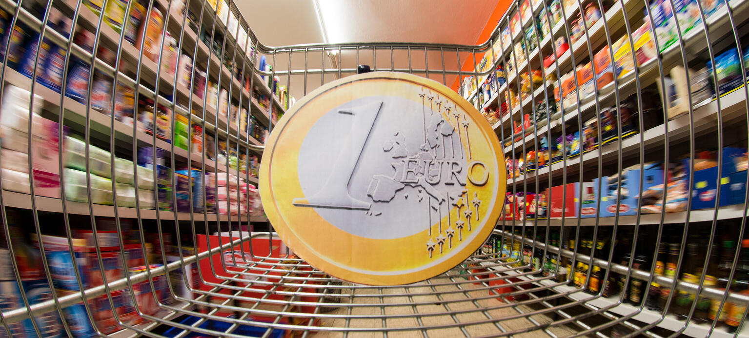 ILLUSTRATION - Eine überdimensionale Euromünze in einem Einkaufswagen