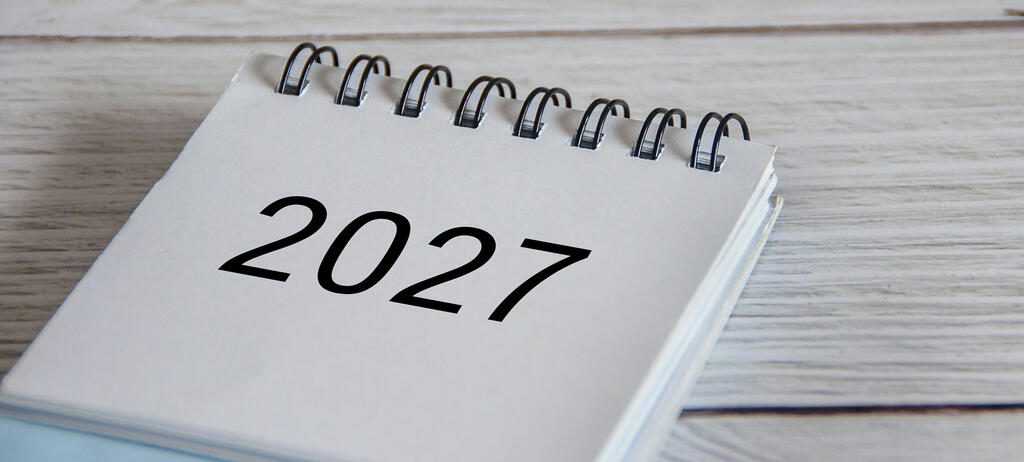 Nahaufnahme des Kalenders 2027 auf Holzuntergrund.