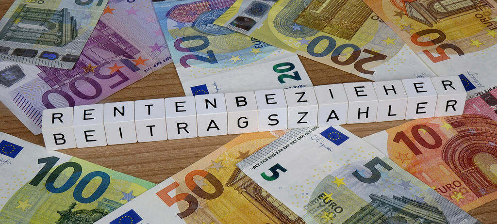 FOTOMONTAGE: Auf verschiedenen Geldscheinen befinden sich Buchstabenwuerfel mit den Schriftzuegen Rentenbezieher und Beitragszahler.
