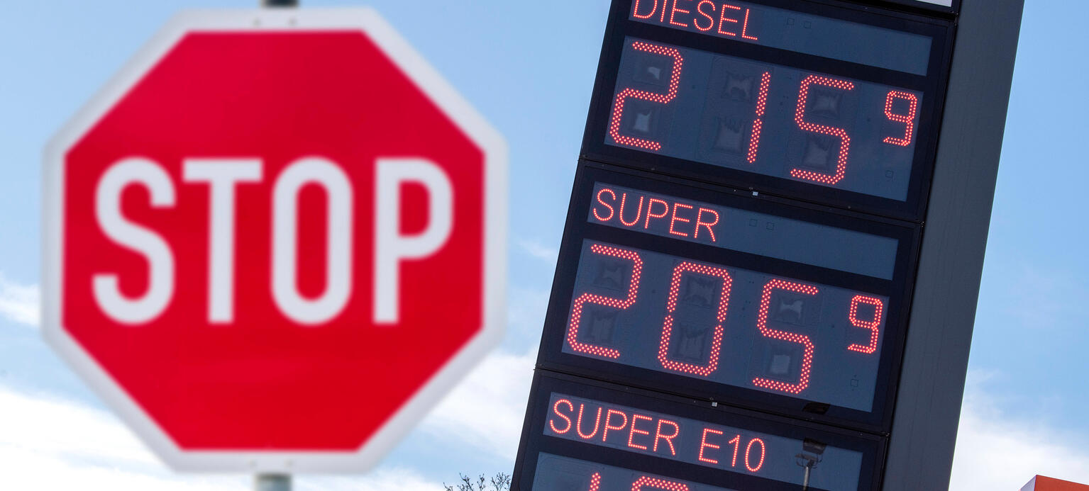 Vor den hohen Spritpreisen für Benzin und Diesel steht ein Stopschild als Symbolbild für eine Benzinpreisbremse.