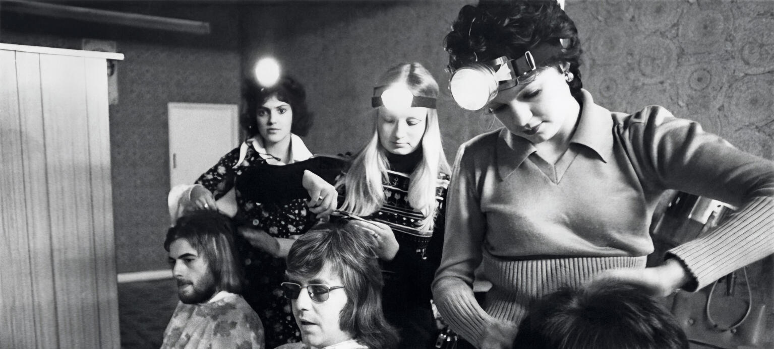 Friseurinnen in Fisher’s Hairdressing Salon in Kent arbeiten während des Blackouts im Schein von Kopflampen.