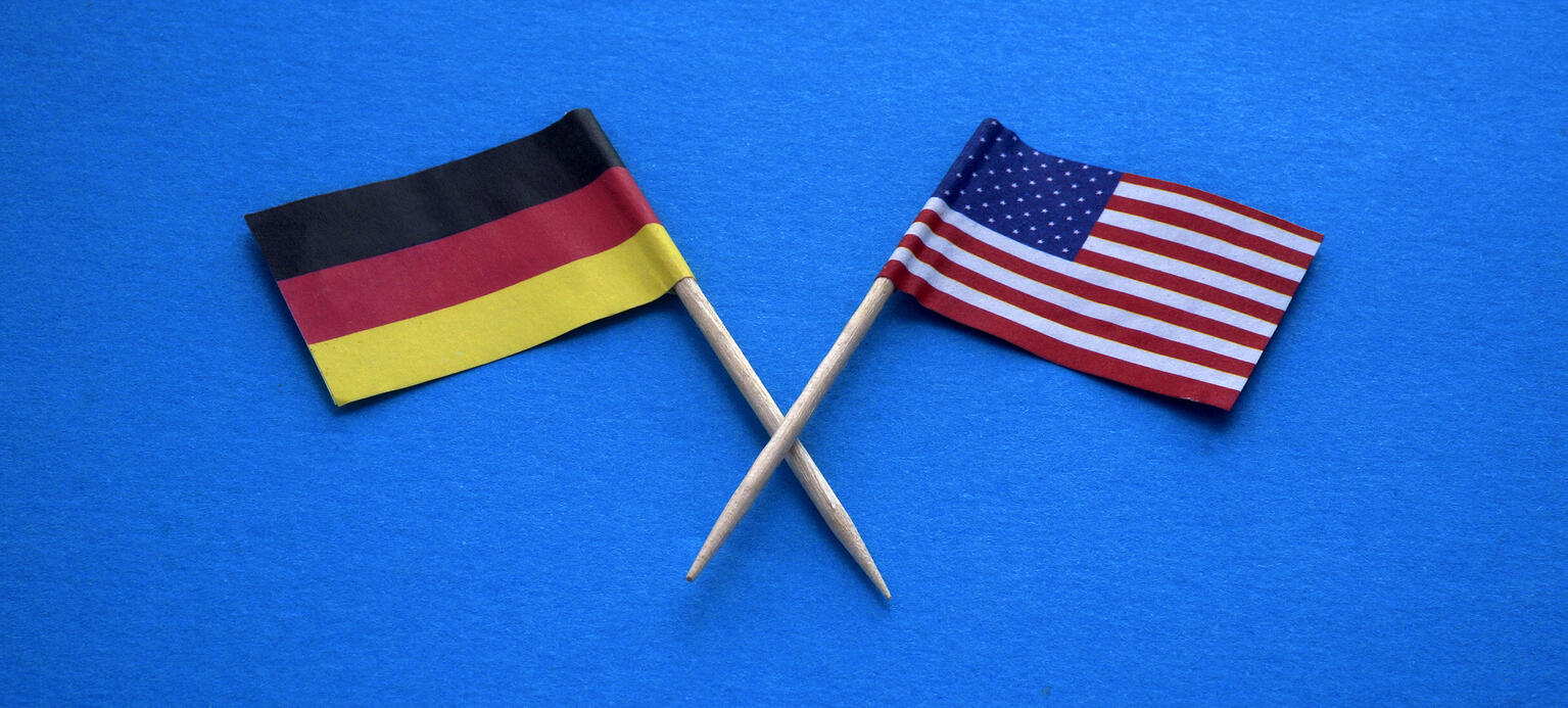 Ein Deutschlandfähnchen und ein USA-Fähnchen kreuzen sich