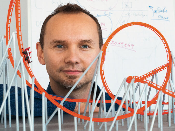 Foto: Torsten Schmidt vor dem Modell einer Achterbahn