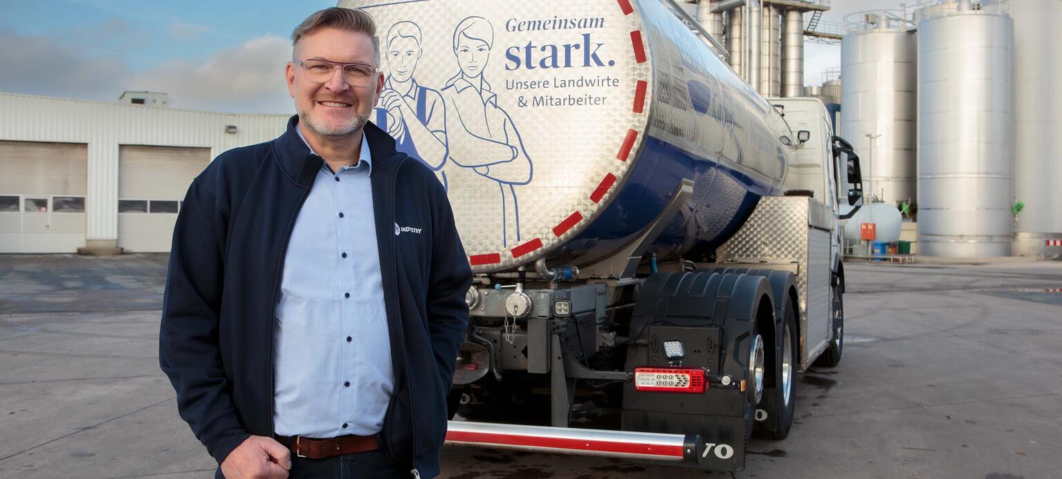 Portrait Thomas Krause, Aufsichtsrat beim Deutschen Milchkontor mit LKW und Werk in Edewecht im Hintergrund