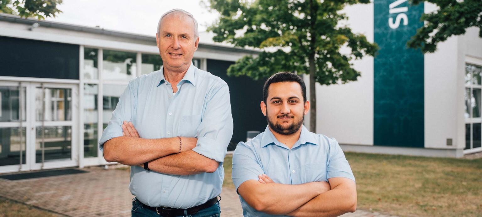 Gemeinsames Bild von Betriebsrat Michael Hellriegel (links) undKhaled Alhaj Sarhan auf dem Außengelände des Leipziger Siemens-Werks