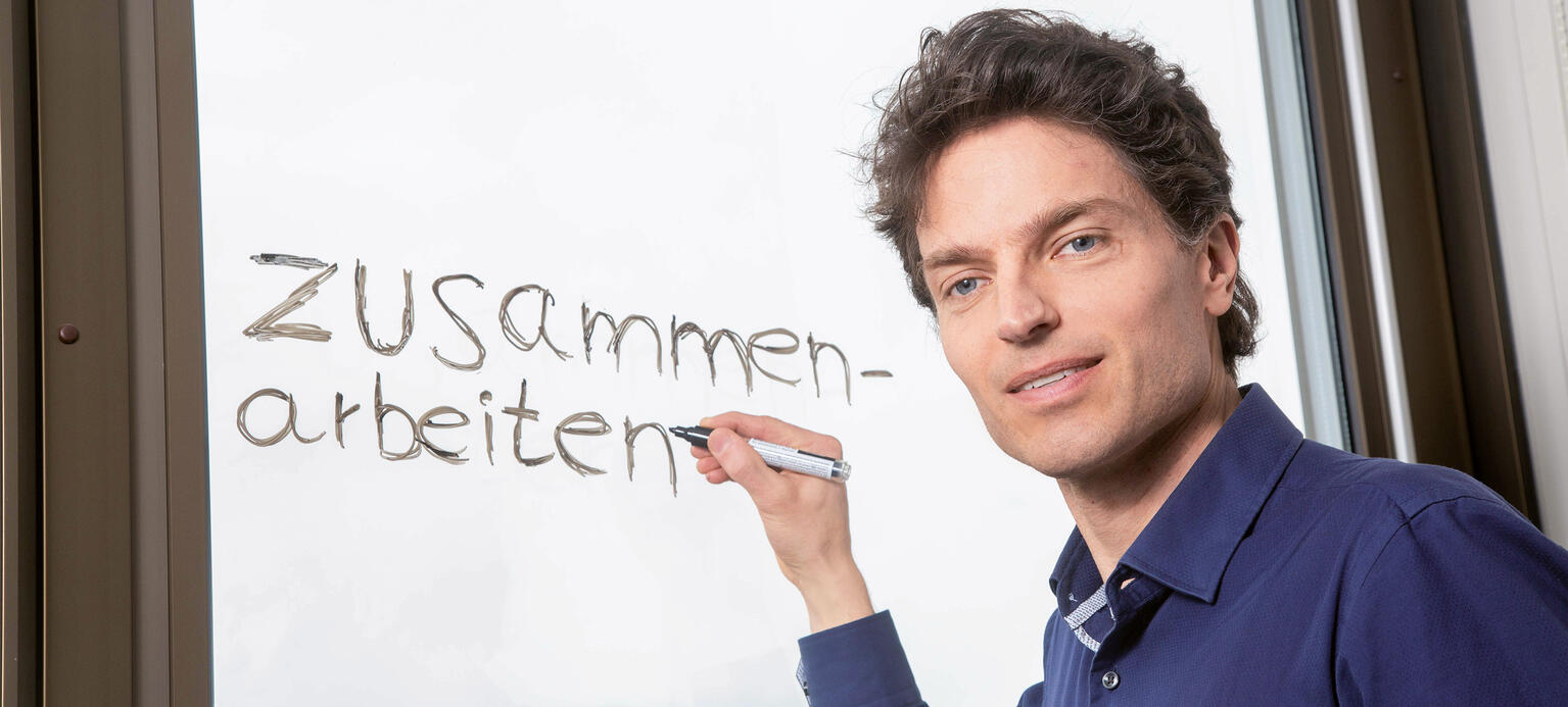 Porträt Enzo Weber, IAB Nürnberg mit Schriftzug 'Zusammenarbeit'