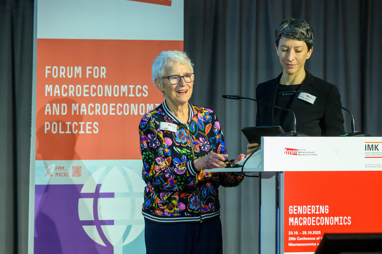 Diane Elson steht am Rednerpult vor dem Auditorium