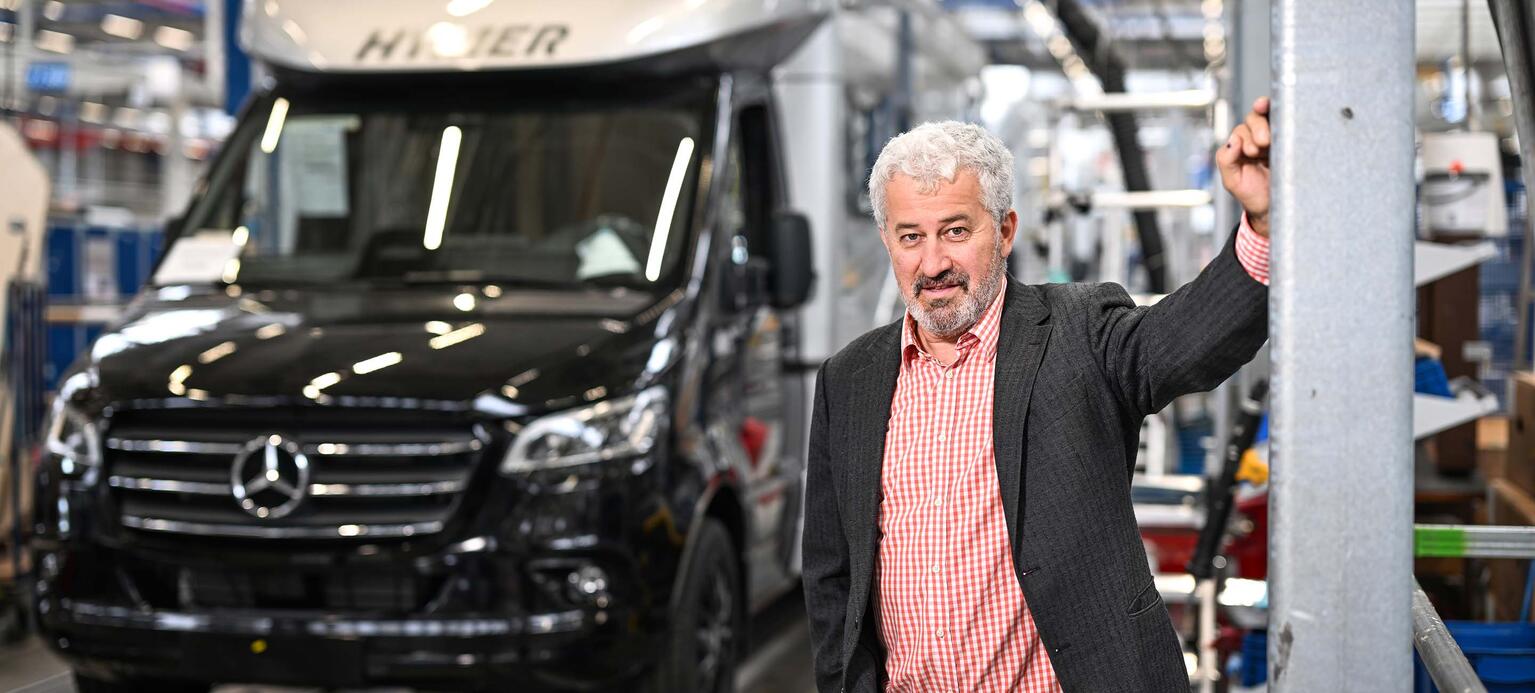 JANUSZ EICHENDORFF, Vorsitzender des Konzernbetriebsrats in Werkshalle mit Fahrzeug